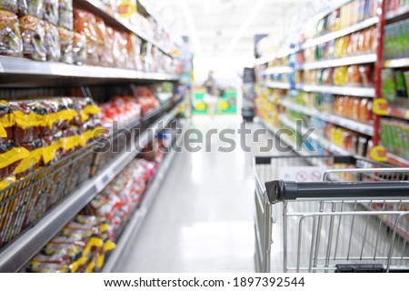 Shopping cart in supermarket, Abstract blurred photo in shopping malls, Cart in the market, wide variety of products are placed on the shelves for an orderly display. Royalty-Free Stock Photo #1897392544