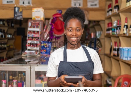 portrait of a female african store attendant smiling Royalty-Free Stock Photo #1897406395