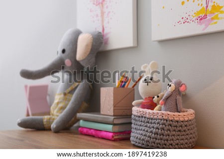 Stationery and toys on wooden table in children's room. Interior design