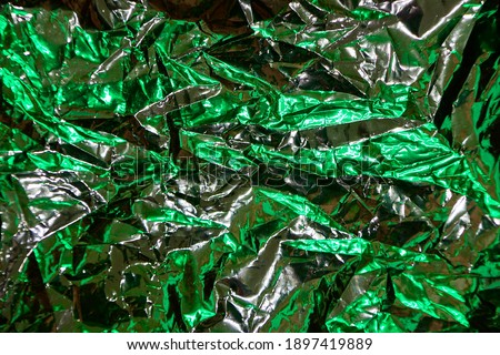 Wrinkled Foil package of snack was being reflected by LED colors lighting with metallic tone color, abstract photo for text quote or background usage.