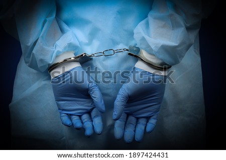 Doctor handcuffed, hands close-up, concept of medical corruption, bribery, crime Royalty-Free Stock Photo #1897424431