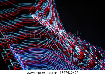 Light painting abstract background. Red and white light painting photography, long exposure, ripples and swirl against a black background.