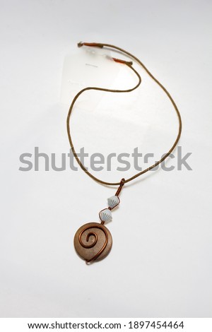bohemian style necklace based on wooden pendant with wire round pattern on white background. Isolated
