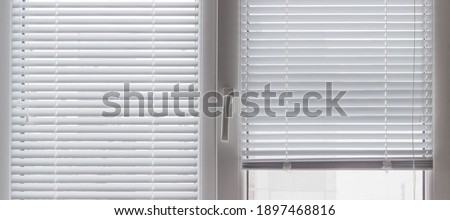 Part of a modern plastic window with partly raised white Venetian blinds and mosquito net, panoramic inside view
 Royalty-Free Stock Photo #1897468816