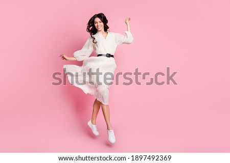 Full length body size photo of girlish cheerful woman in long dress jumping stepping smiling isolated pastel pink color background Royalty-Free Stock Photo #1897492369