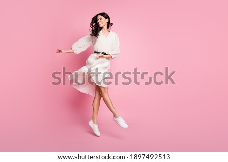 Full length body size photo of dancing woman in long dotted dress jumping looking blank space isolated pastel pink color background Royalty-Free Stock Photo #1897492513