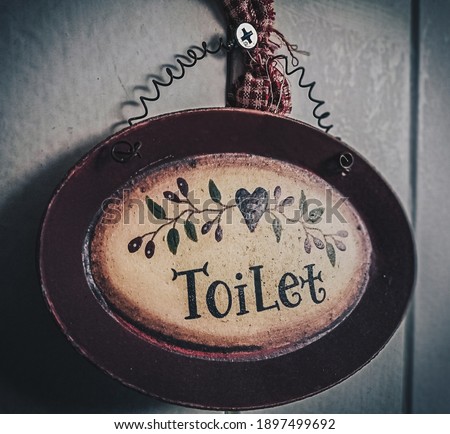 An image of an antique and classic toilet signboard.