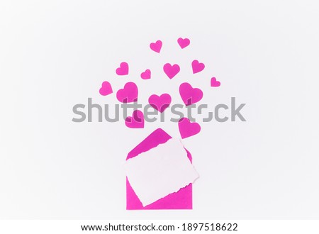 Isolated pink paper hearts and envelope with postcard soar over a white background with copy space