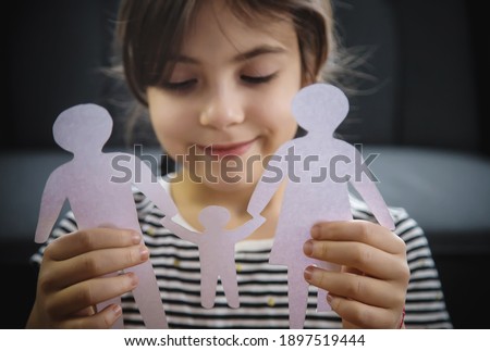 Child with a paper family in his hands. Selective focus. People.