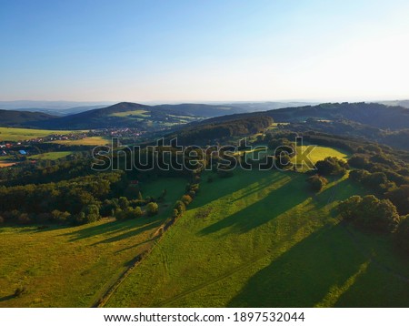 Aerial view of green highland, hills, meadows, fields and pastures in summer morning from drone, Zelechovicke paseky, Czech republic.