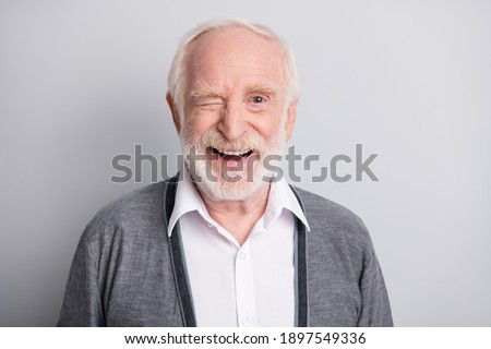 Portrait of old white hair optimistic man blink wear dark sweater isolated on grey background Royalty-Free Stock Photo #1897549336