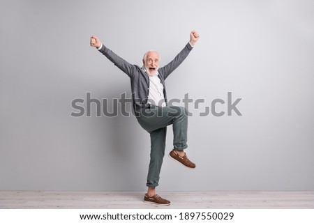 Full size photo of old funny impressed man dance hands fists wear dark sweater trousers boots isolated on grey wall Royalty-Free Stock Photo #1897550029
