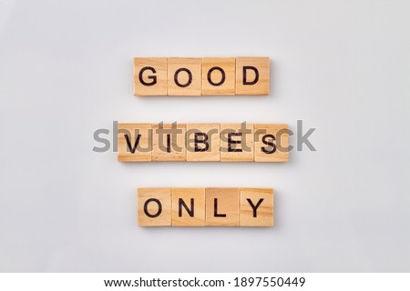 Abstract idea of good vibes. Motivational phrase building with wooden cubes. Isolated on white background.