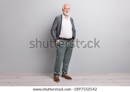 Full size photo of old optimistic man stand wear dark sweater trousers boots isolated on grey wall Royalty-Free Stock Photo #1897550542