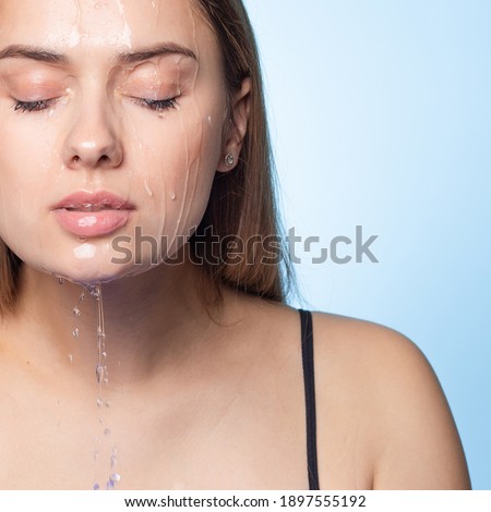 Wash your face, the freshness of clean water on the skin. Portrait of a young beautiful brunette with water drops on her face. The washing and cleansing of the skin, the concept.
