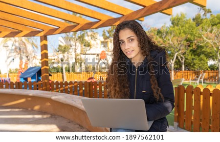 young girl with a laptop in the park