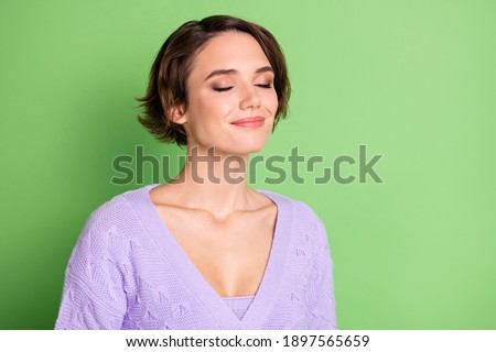 Portrait of adorable young girl closed eyes smile enjoying smell wear purple clothing isolated on green color background Royalty-Free Stock Photo #1897565659