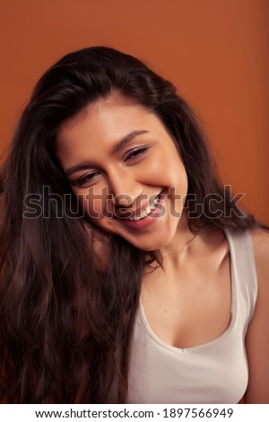 young pretty girl with curly hair posing cheerful on brown background, lifestyle people concept