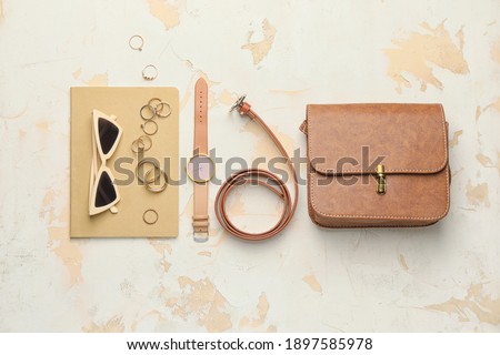 Stylish bag with female accessories on white background Royalty-Free Stock Photo #1897585978