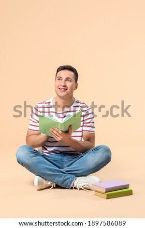 Male student studying on color background