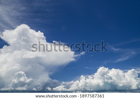 Atmospheric picture of a blue sky with voluminous white clouds.