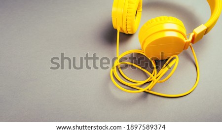 Yellow headphones on a gray background, top view