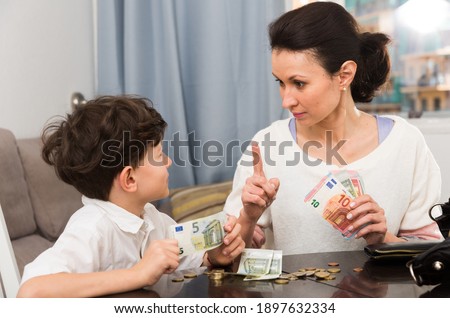 Mom making instructions to her preteen son when she giving him pocket money.. Royalty-Free Stock Photo #1897632334