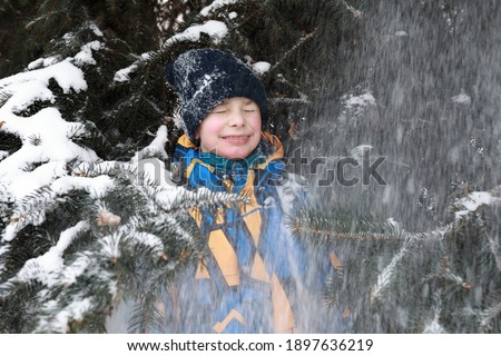 Portrait of child on background of Christmas tree in park