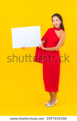 Portrait beautiful young asian woman empty white billboard yellow background