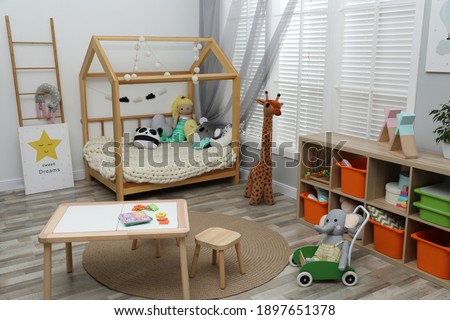 Cute child's room interior with toys and wooden furniture