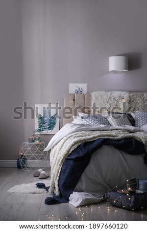 Cozy bedroom interior with warm blanket and cushions