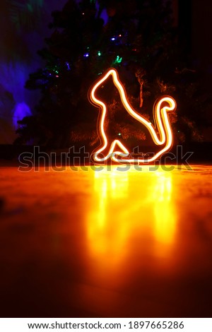 Neon sign yellow cat in the decor. Merry Christmas background. New Year. Trendy style. Neon sign. Custom neon. Home decor.