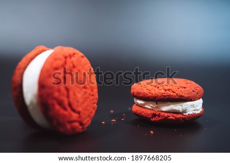 Red and white macarons isolated on black background. French macaroons cake (or macarons) background. Minimal food photography concept. Top view with copy space.