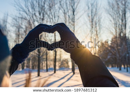 Valentine's Day, heart from hands, woman making heart symbol.Valentines day.Sunset winter outdoors background.