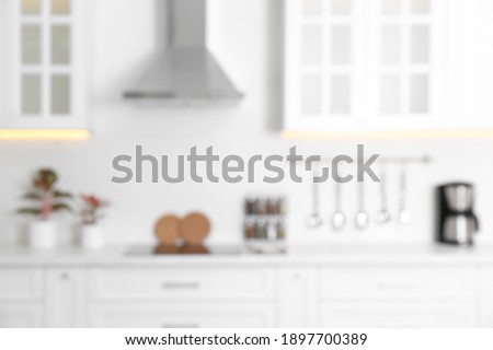 Blurred view of modern kitchen with white furniture