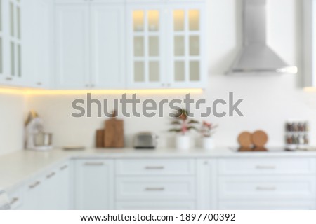 Blurred view of modern kitchen with white furniture