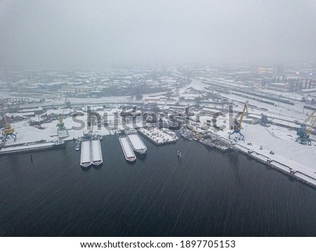 Blizzard in the industrial port. Snowy day, blizzard. Aerial drone view.