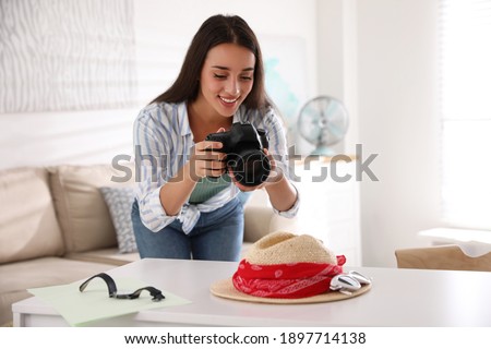 Young photographer taking picture of accessories indoors