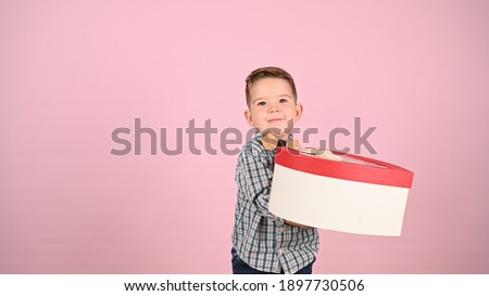 Child holding a gift box, heart-shaped. High quality photo
