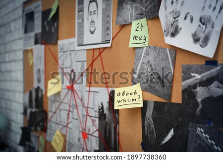 Detective board with stickers, crime scene photos and red threads, closeup