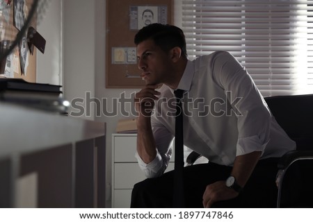 Professional detective smoking cigarette in his office
