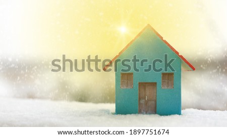 Miniature blue wooden house on the sun snowly