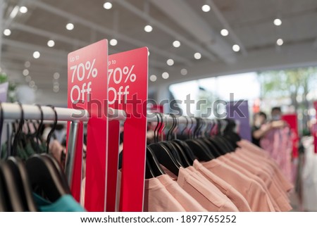Big sale tag announcement at clothes shop, Black friday and shopping concept, Red tag 70 percent discount price in shop.