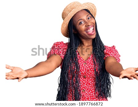 Young african american woman wearing summer hat smiling cheerful offering hands giving assistance and acceptance. 