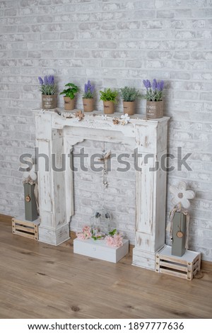 Spring summer decor with wood fireplace, lavender, basil, oregano, rosemary and flowers for studio photography