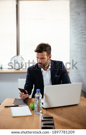 Businessman typing a message. Company manager on his phone sending a message.