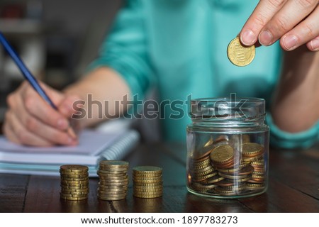 A woman saves money for her future personal projects.
 Royalty-Free Stock Photo #1897783273