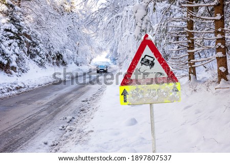 road sign warns of ice and snow at winter