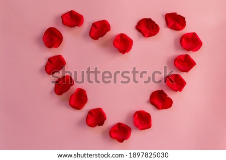Heart formed by rose petals with copy space on pink background. Love concept.