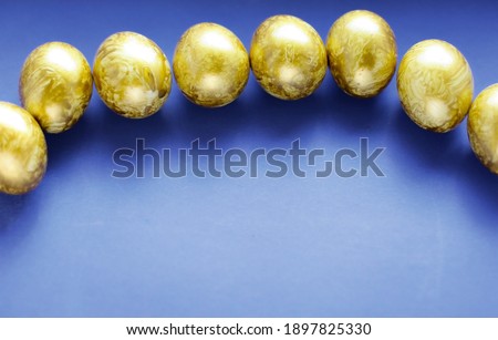 Top view easter composition. Easter greeting card with golden eggs on a blue background, copy space.